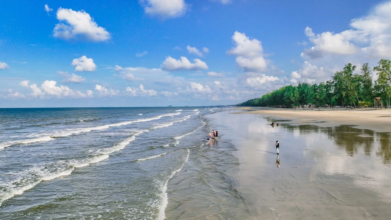 The wide sands and casuarina treeline of An Bang Beach near Hoi An