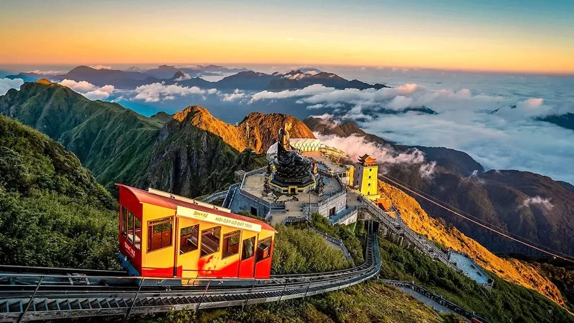 The Fansipan funicular tram climbing past the summit Buddha above a sea of cloud at Sun World Fansipan Legend, SaPa