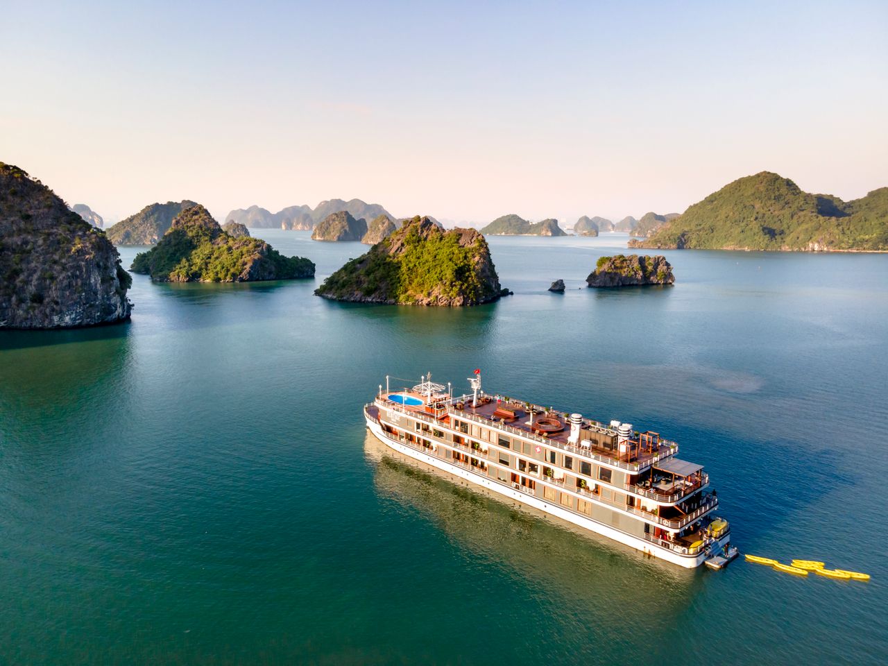 An overnight cruise ship anchored among the limestone karsts of Halong Bay — Vietnam DMC by Fiesta Asia Travel